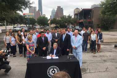 Gov. Greg Abbott signs into law statewide regulations for ride-hailing companies.