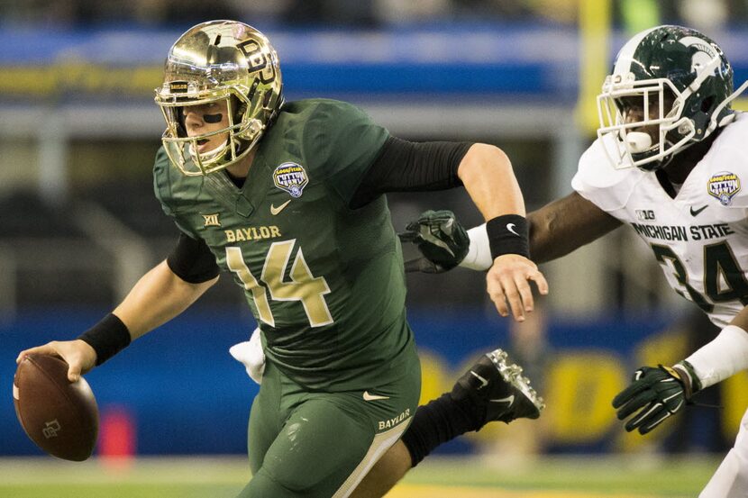 Baylor quarterback Bryce Petty (14) scrambles under pressure from Michigan State linebacker...