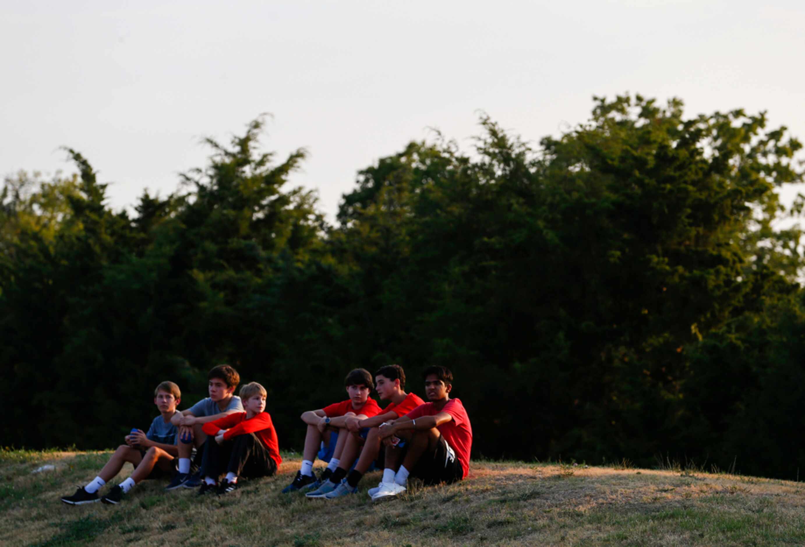 Young Parish Episcopal fans watch the game from a hill during a high school football game...