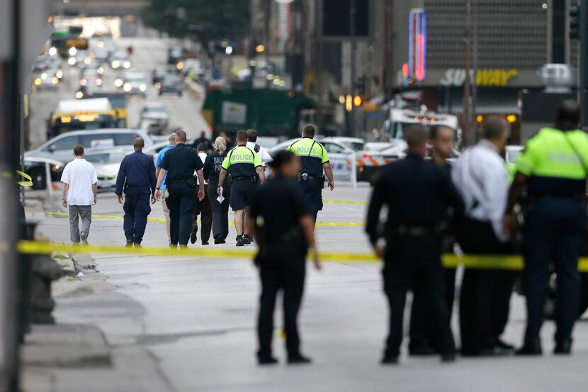Investigators walked the scene of the shooting in downtown Dallas on Friday. 