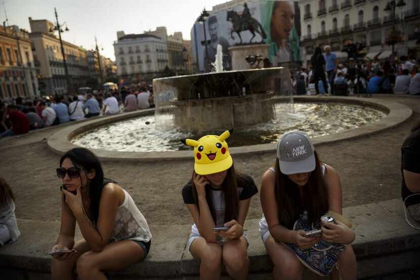 Spanish fans play the highly addictive Pokemon Go game during a gathering in central Madrid,...