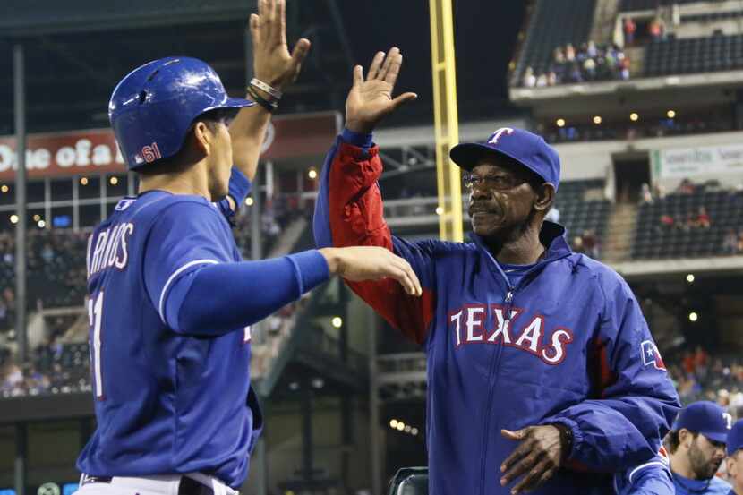 Texas manager Ron Washington greets catcher Robinson Chirinos after he scored a run in the...