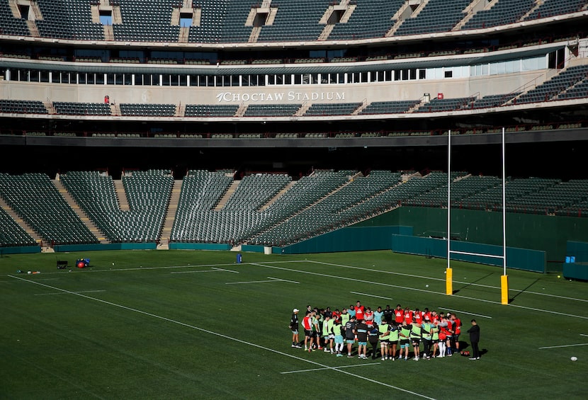 Members of the Dallas Jackals rugby team join arms during a break where they practice and...