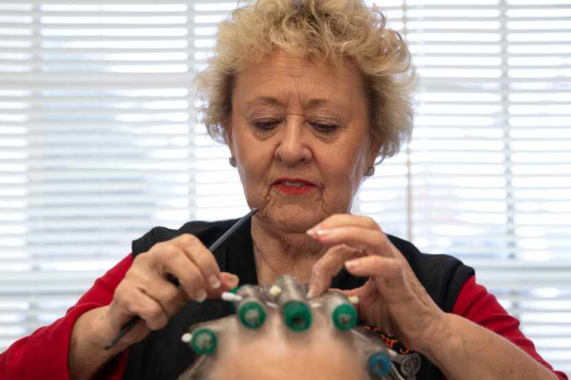 O'Neal sets curl rollers for a client. In operation since 1966, her shop has long been a...