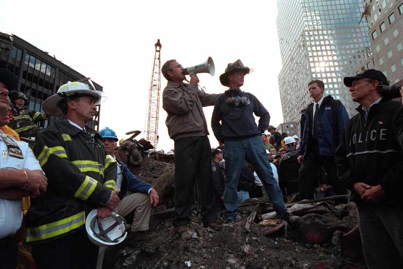 Standing atop rubble with retired New York City firefighter Bob Beckwith, Former President...