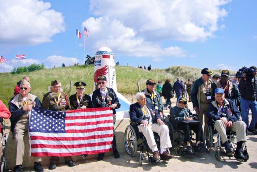 
Joe Geary (far right), and other veterans pose for a group photo at the Utah Beach American...