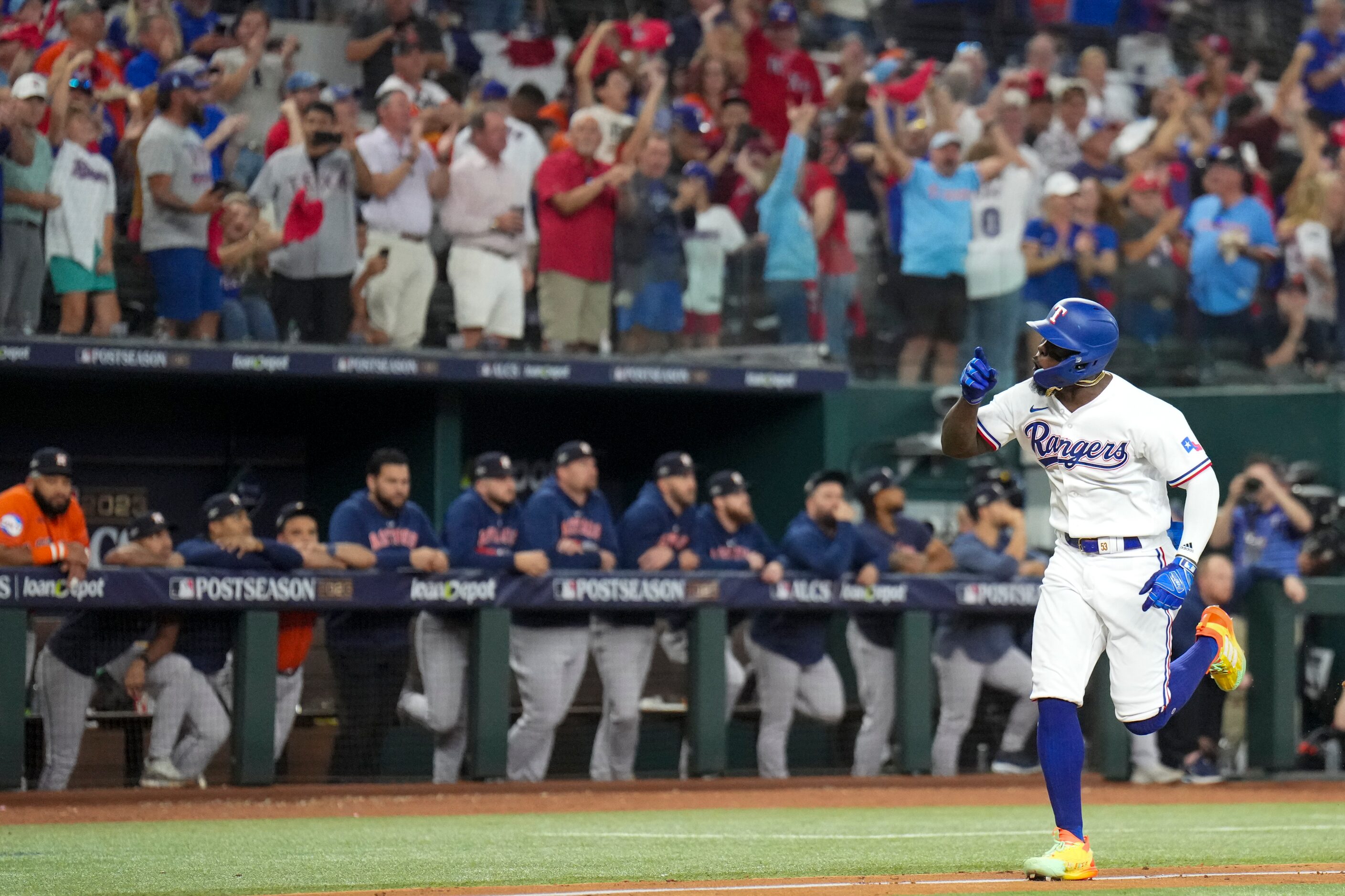 Texas Rangers batter Adolis Garcia  points celebrates after hitting a three-run homer off of...