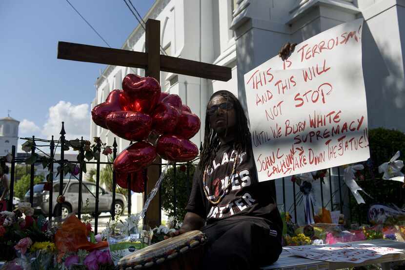 A man held up a sign about white supremacy outside Emanuel AME Church on Saturday in...