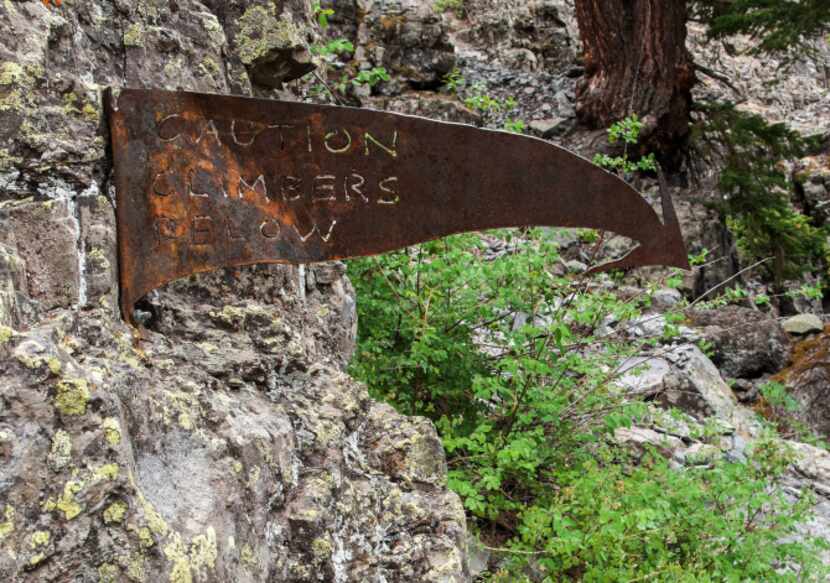 A rusty arrow gives an artful warning that climbers may occupy the rocks below.  The cliffs...