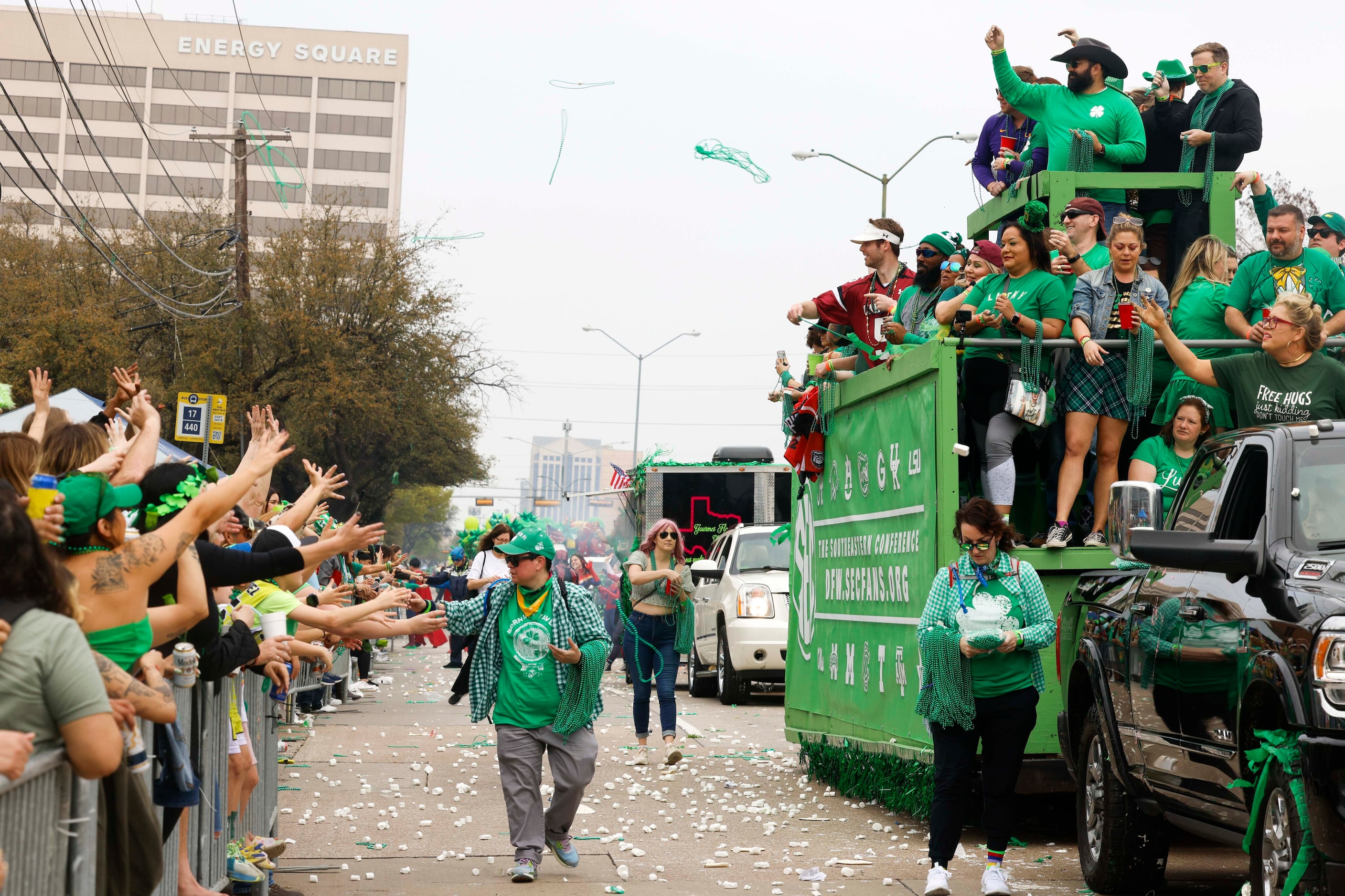 Southeastern Conference team tosses green beads towards the crowd during a Saint Patrick's...