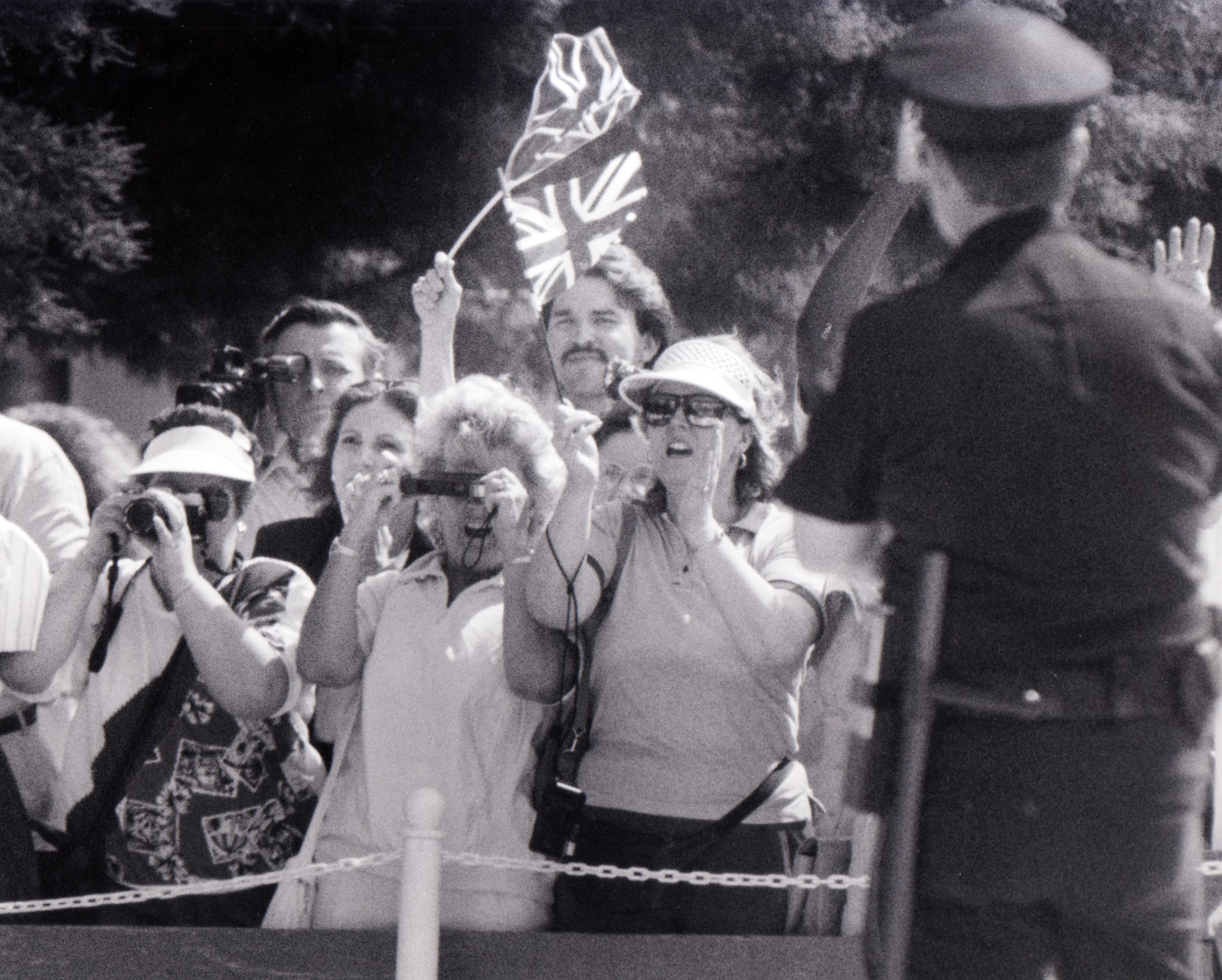 A crowd waits on May 21, 1991, for a glimpse of Queen Elizabeth II as she leaves the Morton...