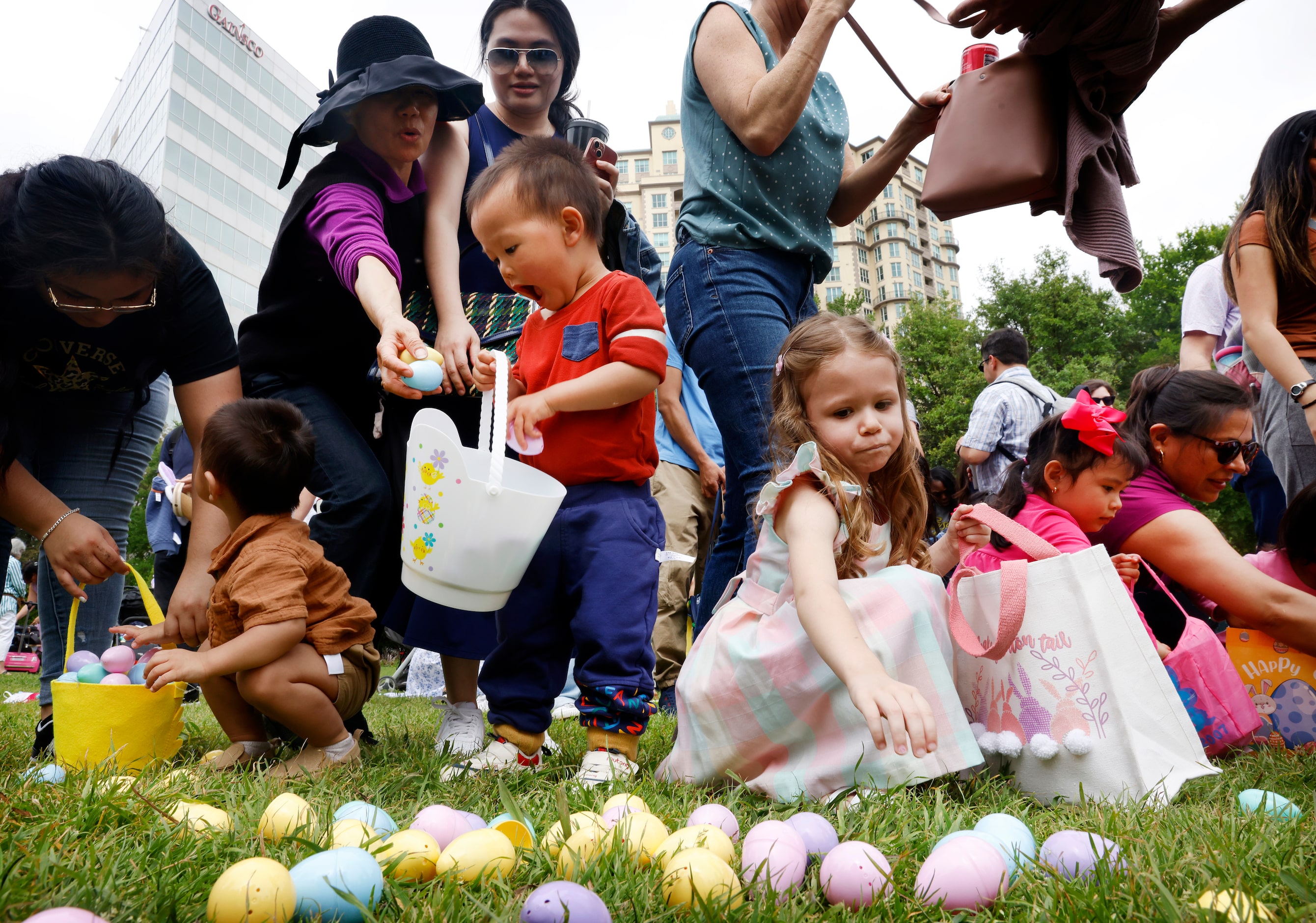 Children scramble to collect Easter eggs during a hunt at Easter in Turtle Creek Park in...