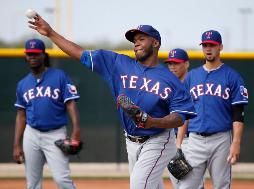 Texas Rangers pitcher Neftali Feliz (30) fields a ball during a workout drill at the Rangers...