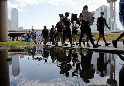 Protesters march to the Frank Crowley Courts Building during their march to remember the...
