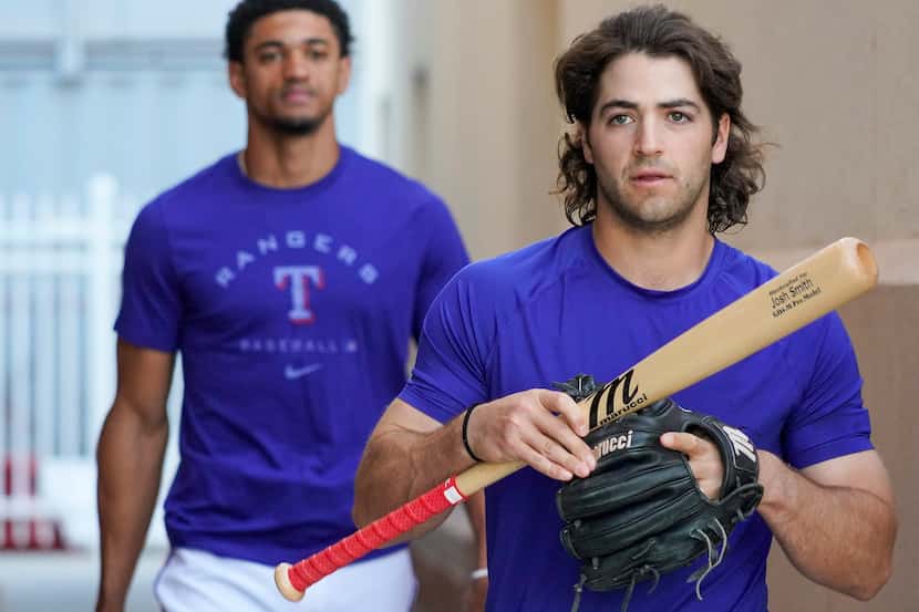 Texas Rangers infielder Josh Smith (front) and outfielder Bubba Thompson walk from the...