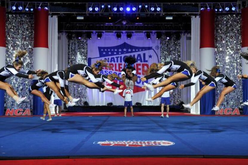 
Hebron cheer team members leap above the performance floor as part of their routine at...