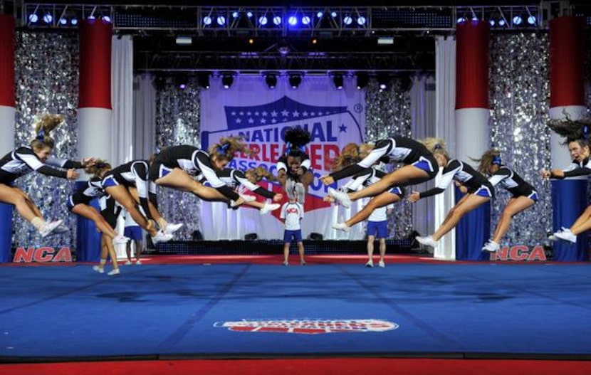 
Hebron cheer team members leap above the performance floor as part of their routine at...