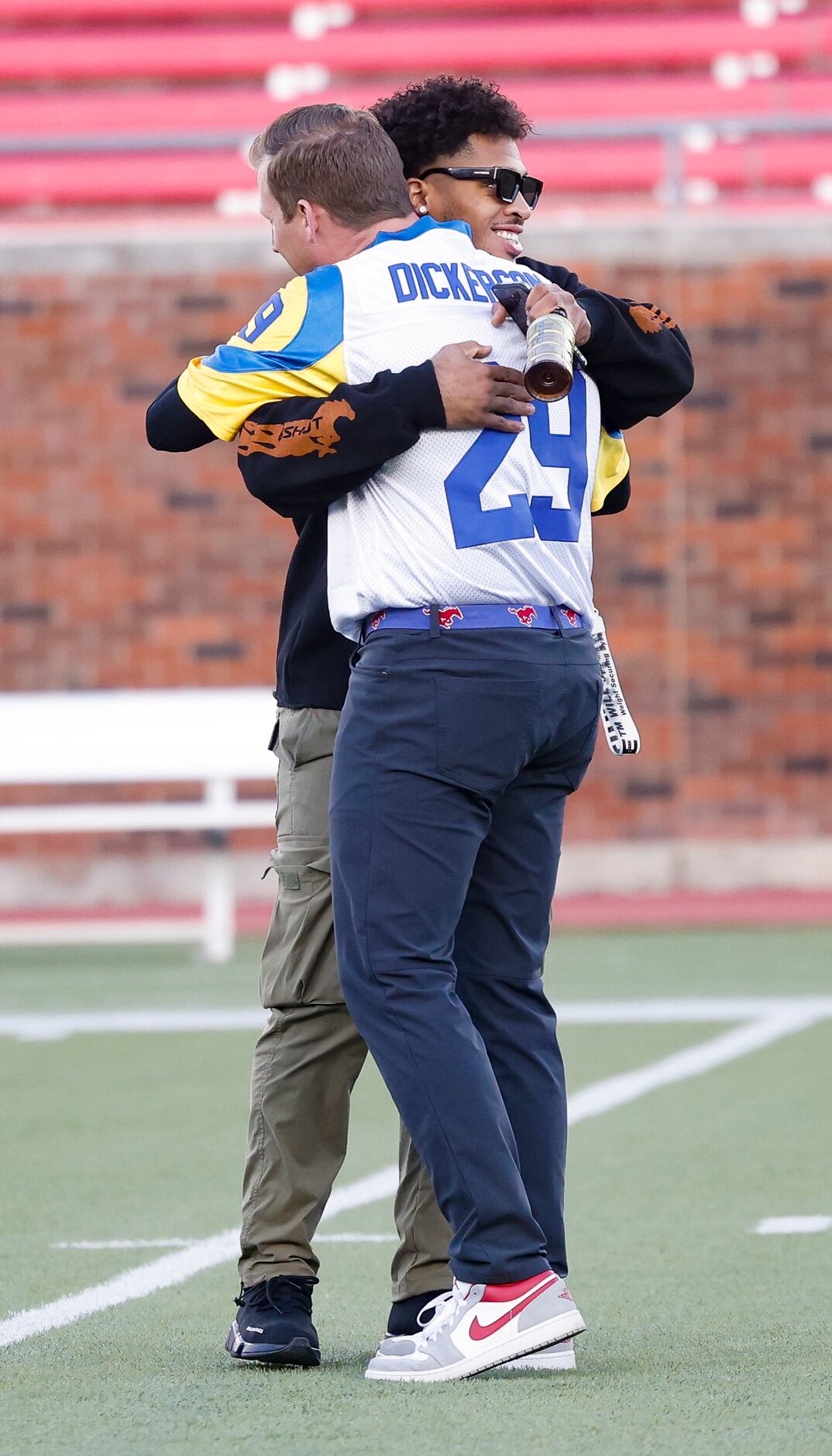 Coach Rhett Lashlee hugs Los Angeles Rams running back and former SMU player Xavier Jones...
