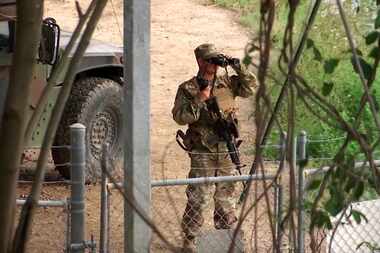 A National Guardsman watches over Rio Grande River on the border in Roma, Texas on April 10,...