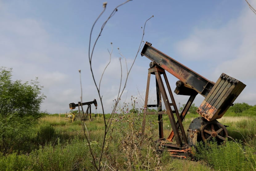 Pump jacks sit idle on a South Texas ranch near Bigfoot. Deserted drilling wells are the...