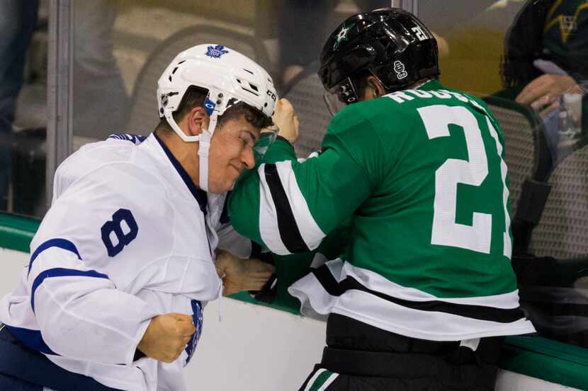 Dallas Stars left wing Antoine Roussel (21) takes a punch from Toronto Maple Leafs...