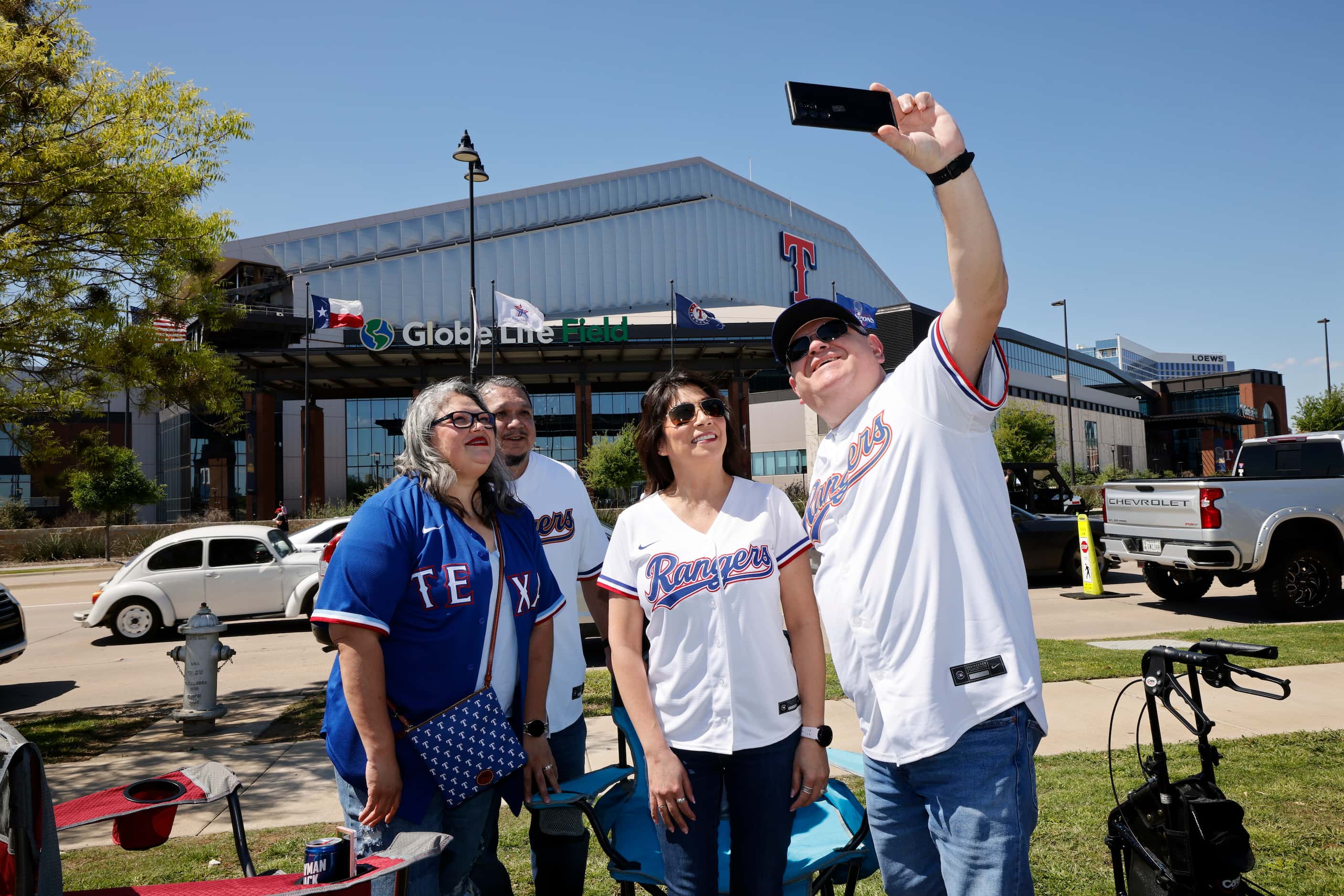 Texas Rangers fans Arthur Barajas of Mesquite, Texas, right, take a selfie with his wife...