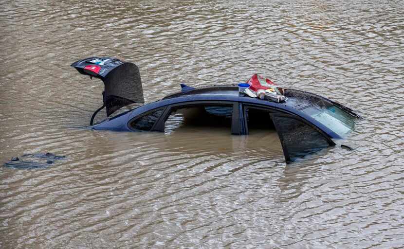 Items found in a submerged car  in Garland sat atop it Friday after rescue teams removed a...
