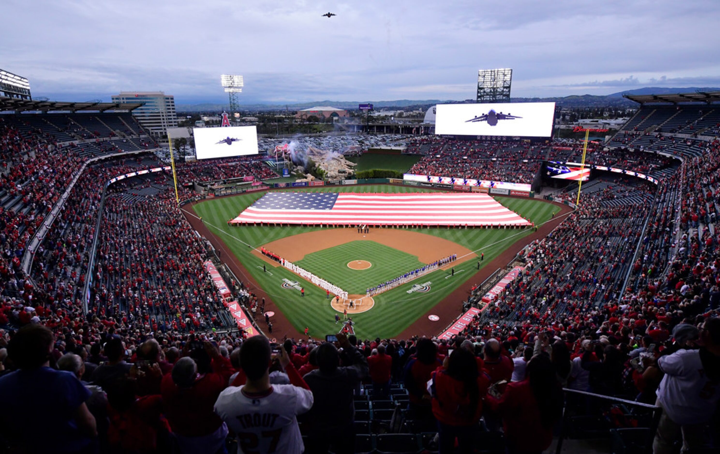 A military aircraft flies over during the national anthem for Los Angeles Angels'...