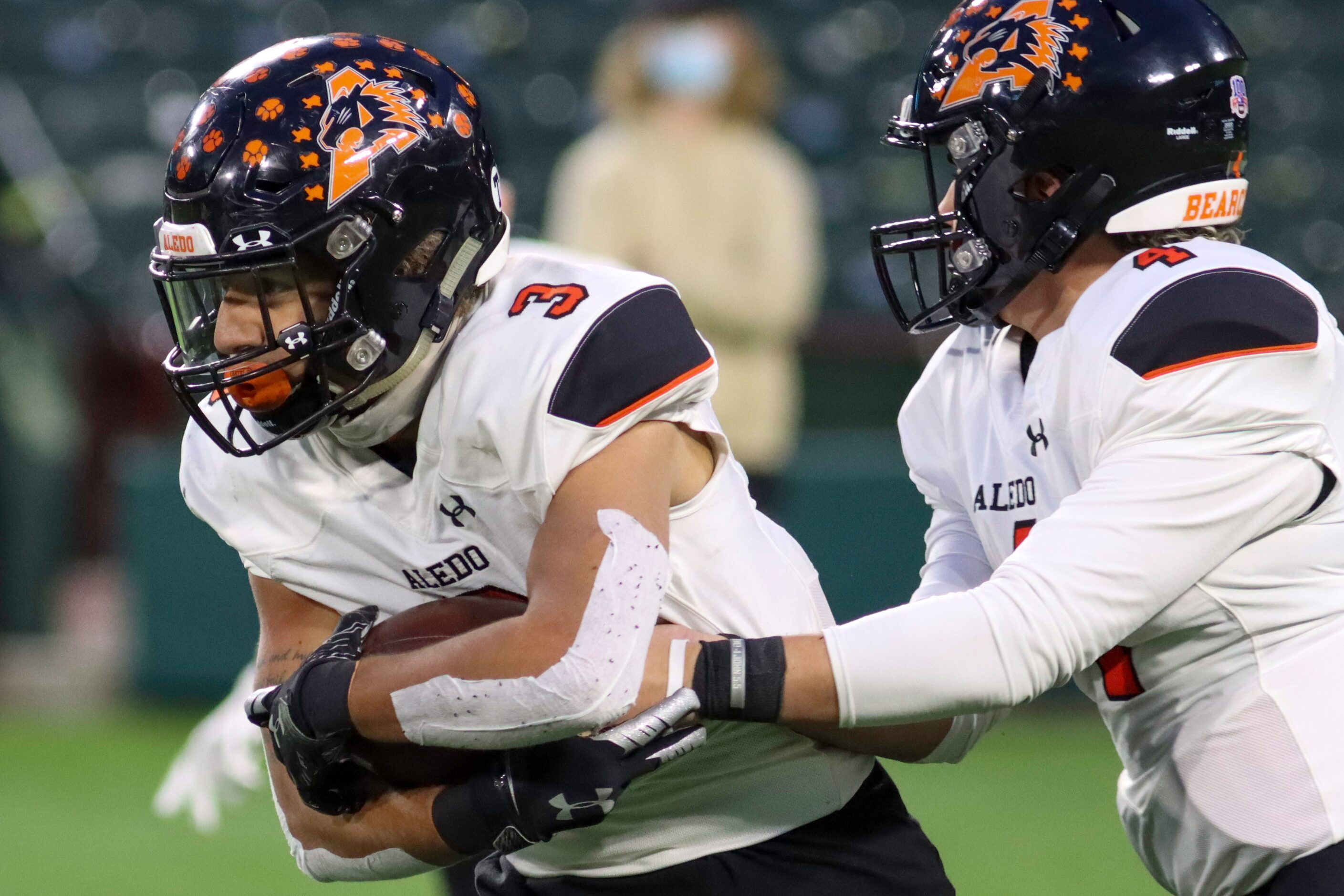 Aledo quarterback Ethan McBrayer (4) hands the ball to running back Jeremiah James (3)...