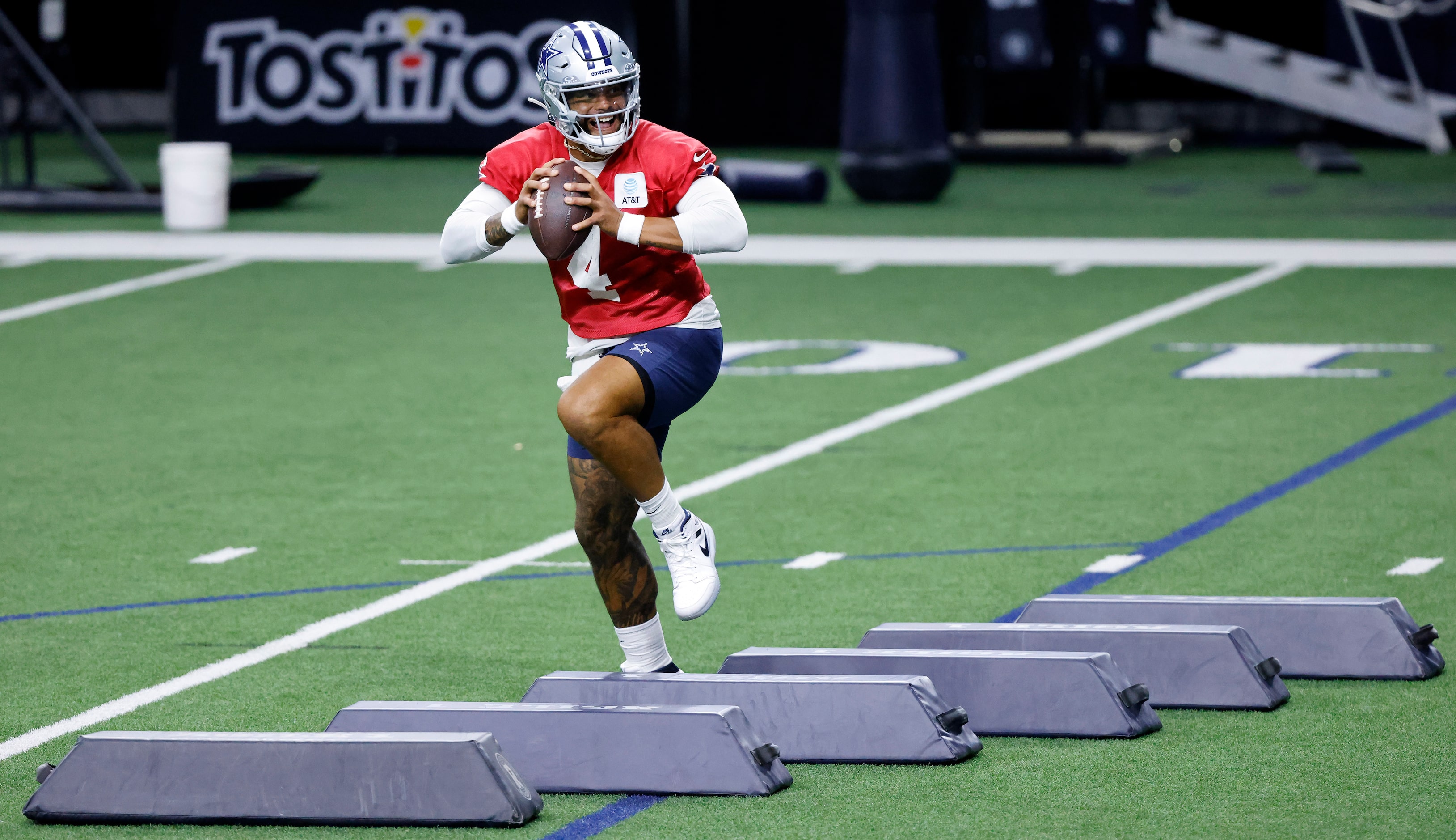 Dallas Cowboys quarterback Dak Prescott (4) runs over the pads as he looks downfield during...