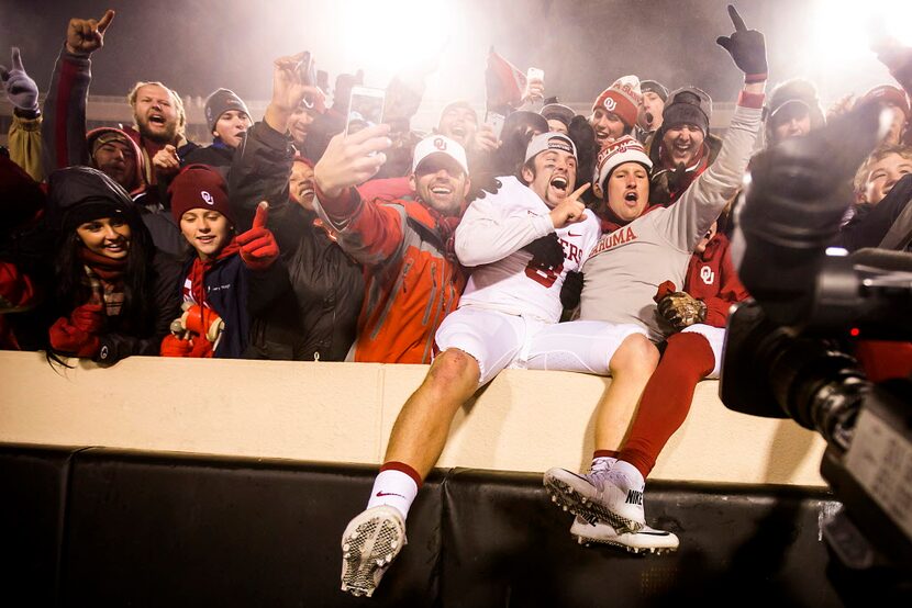 Oklahoma quarterback Baker Mayfield celebrates with fans following a 58-23 victory over...