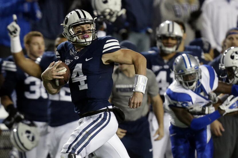 FILE - In this Sept. 27, 2013, file photo, BYU quarterback Taysom Hill (4) scores as he...