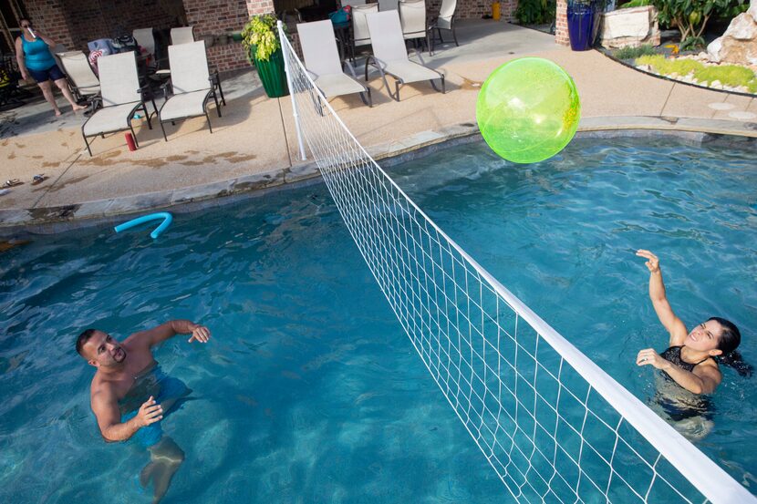 Tony Banda (left) and sister Imelda Mendoza pass the ball at a pool they rented using the...