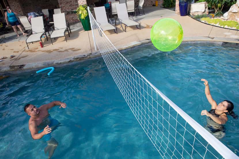 Tony Banda (left) and sister Imelda Mendoza pass the ball at a pool they rented using the...