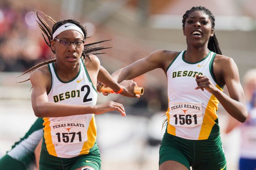 DeSoto's Rosaline Effiong (right) hands off the baton to Caitlin Shaw (left) during the High...