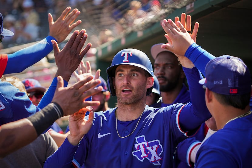 Texas Rangers outfielder Brad Miller celebrates with teammates after hitting a 2-run home...