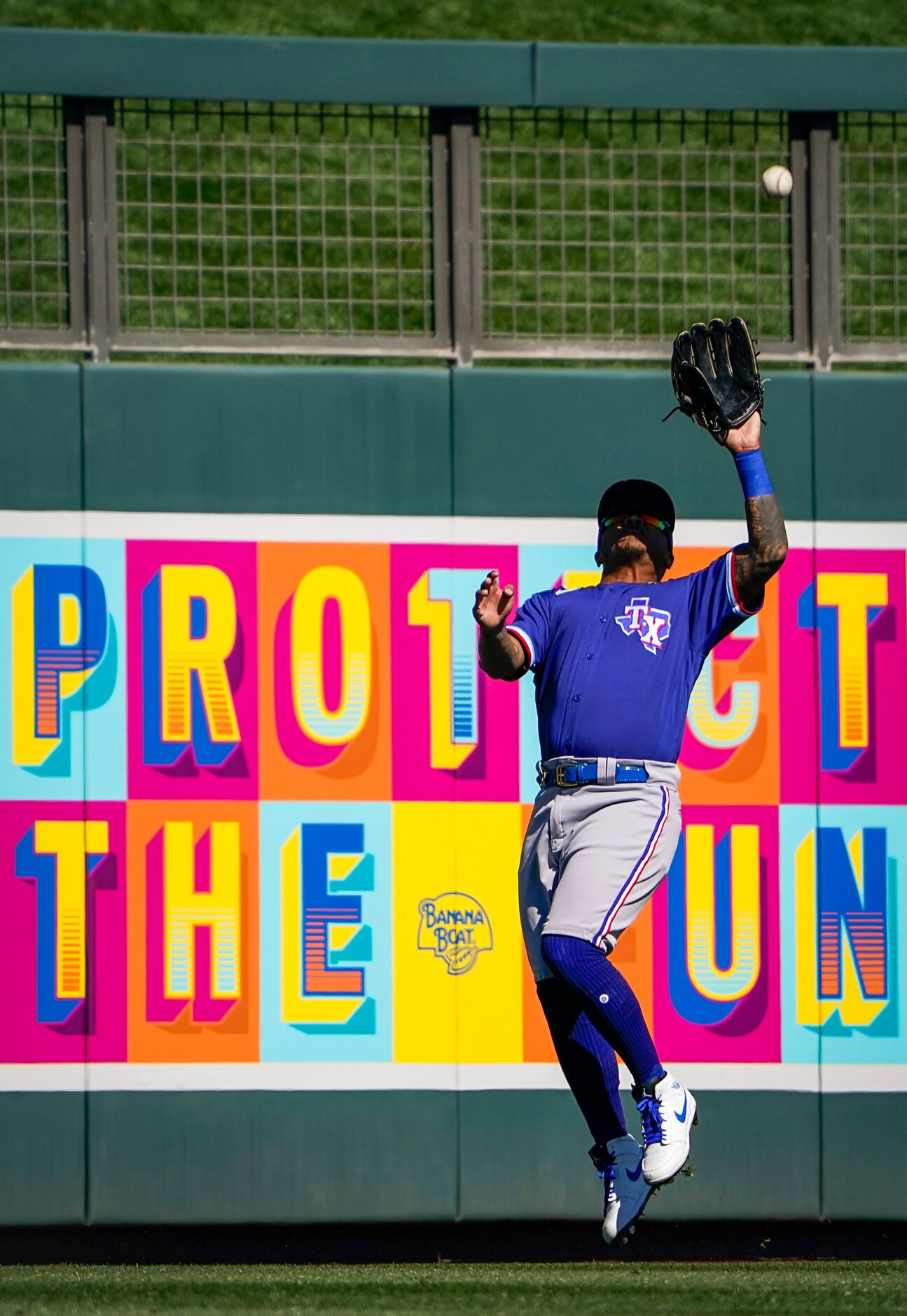 Texas Rangers outfielder Willie Calhoun makes a leaping catch on a line drive off the bat of...