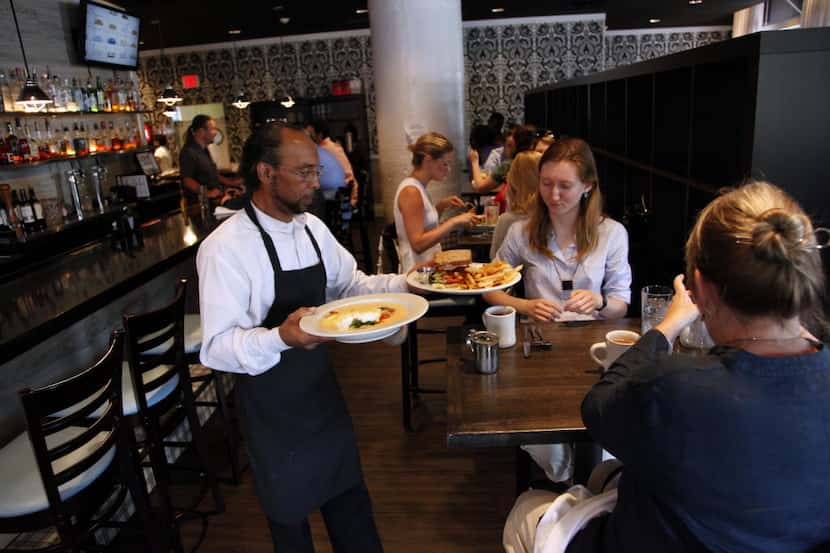 Server Richard Pruitt serves patrons lunch at Ellen's Southern Kitchen in the West End in...