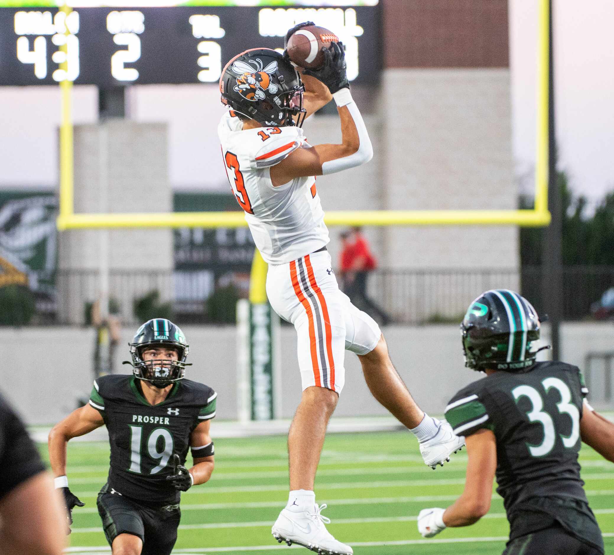 Rockwall wide receiver Kai Helton (13) makes a catch between Prosper's Bo Mongaras (19) and...