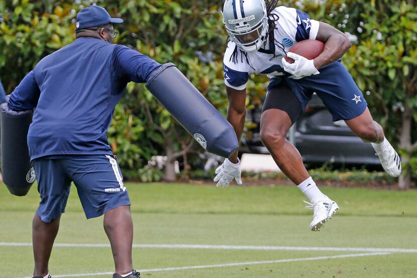 Dallas Cowboys running back Bo Scarbrough (36) leaps to avoid running backs coach Gary Brown...