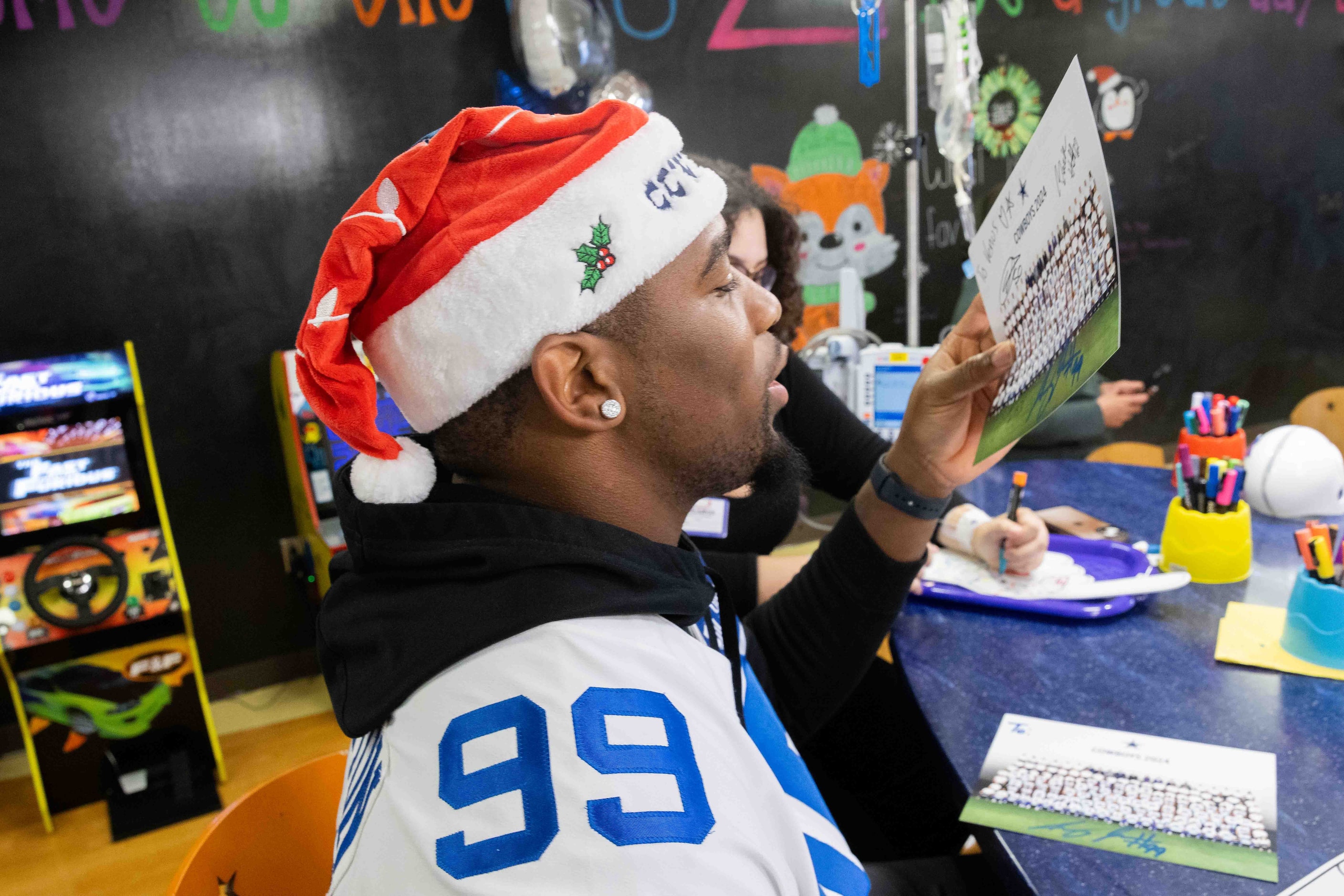 Dallas Cowboys defensive end Chauncey Golston (99) ensures his signature is dry after...