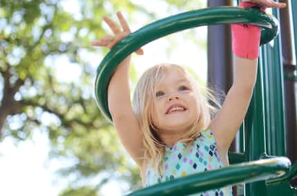 Young girl smiling and playing on a playground