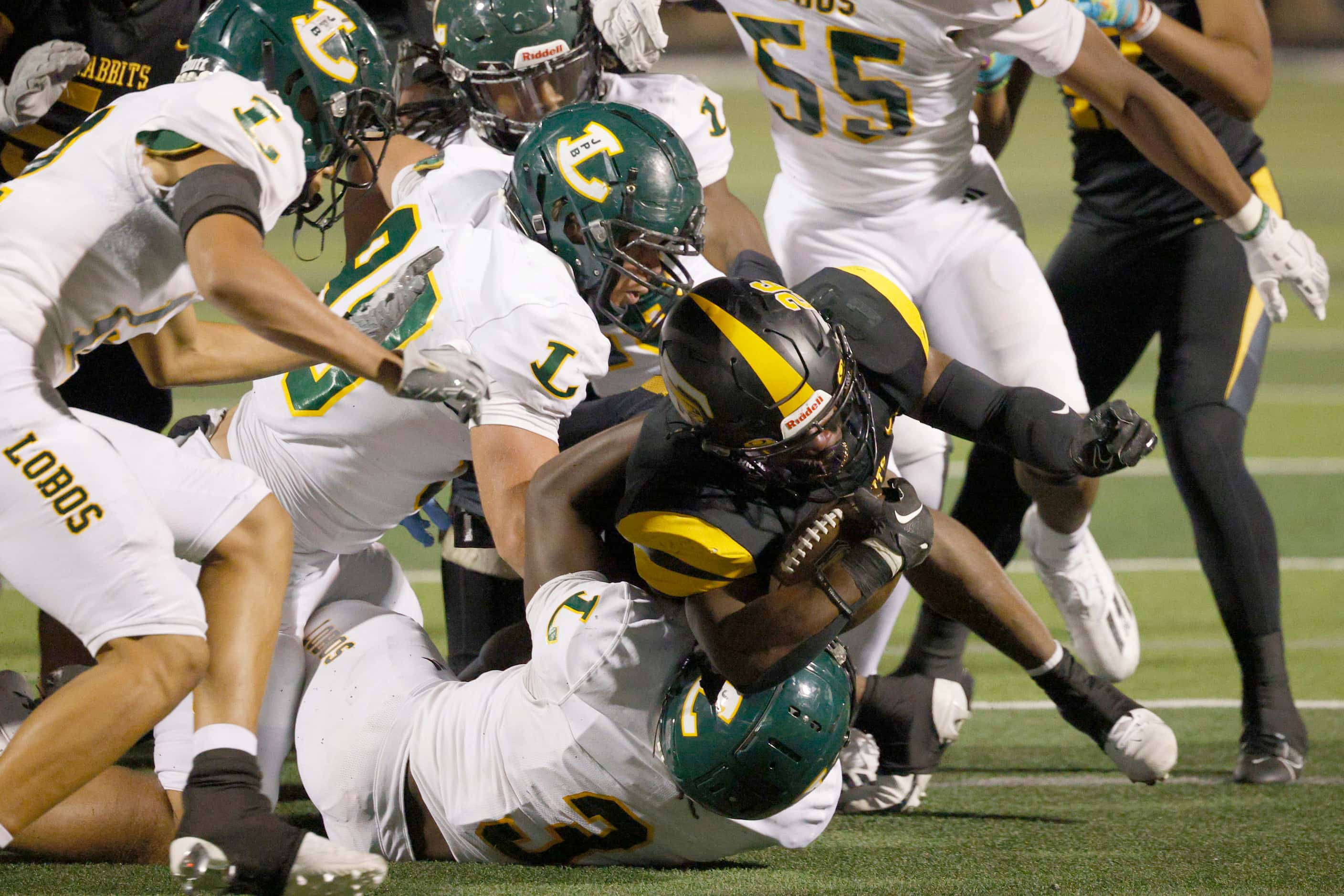 Longview’s defense players go to stop Forney's Javian Osborne (26) during the second half of...