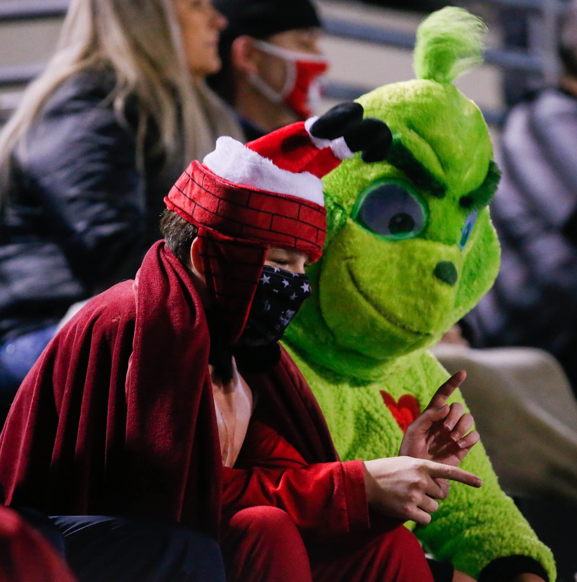 Frisco Lone Star fans Carter Tibbits, 13, (left) dressed as "sexy Santa" and Austin...