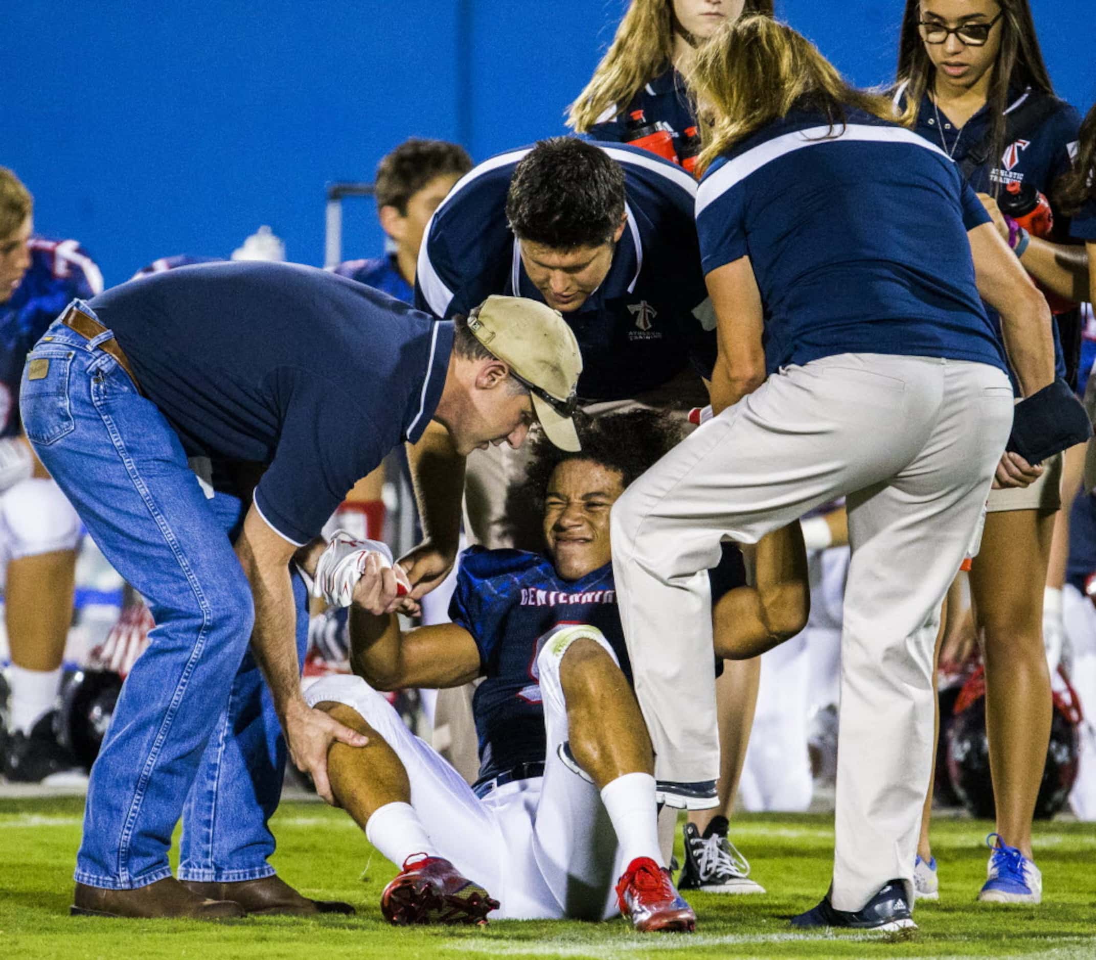 Frisco Centennial wide receiver Raleigh Texada (9) winces as he's helped up by trainers...