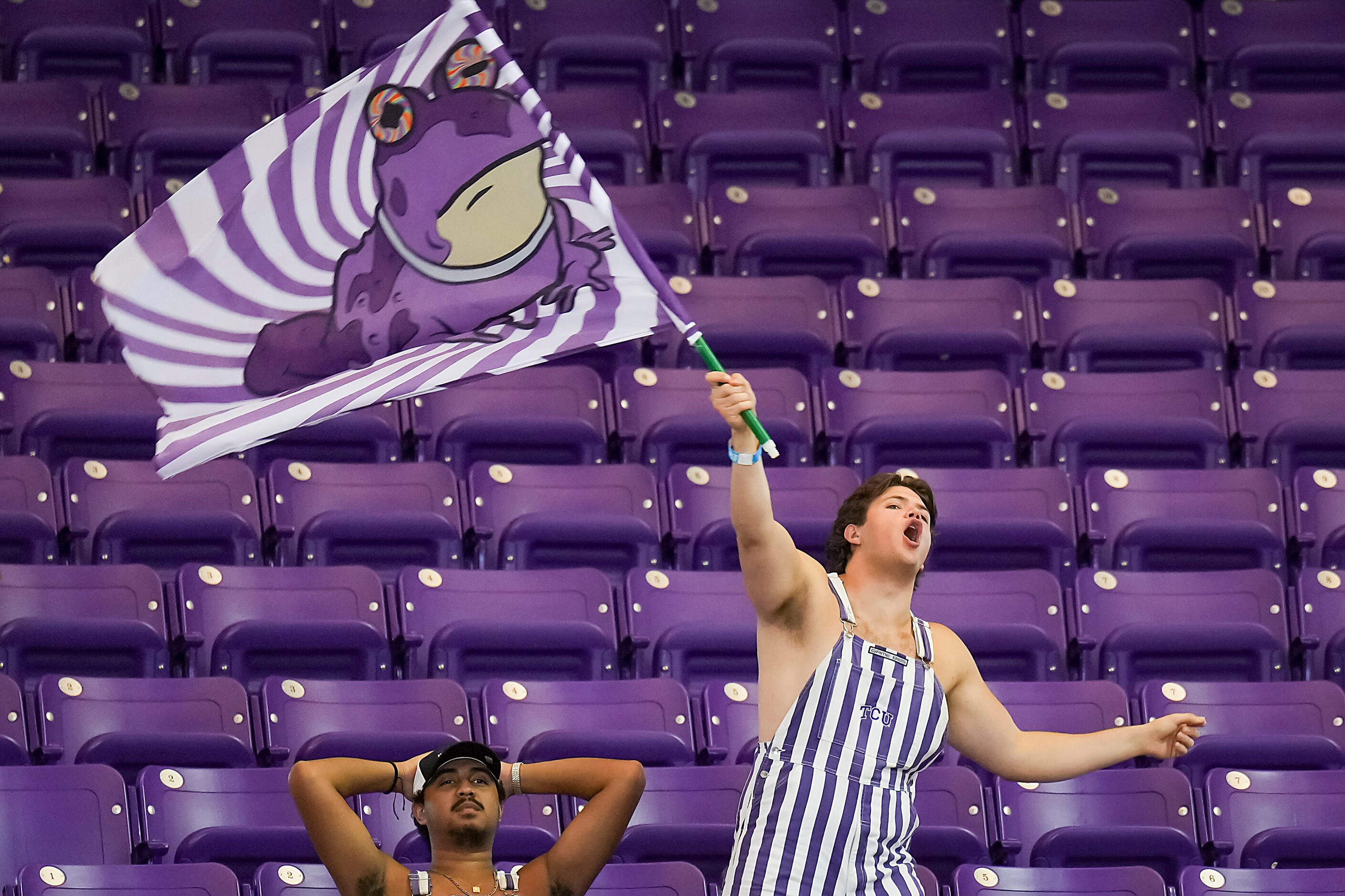 Brady Raboin, a member of the TCU Dutchmen, waves a Hypnotoad flag, as fans watch the fourth...