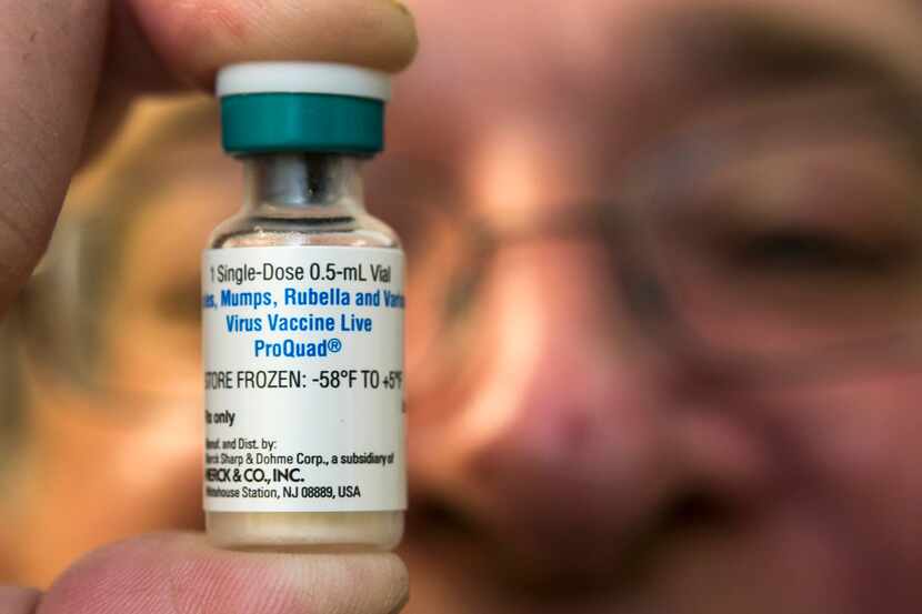 A pediatrician holds a dose of the measles-mumps-rubella (MMR) vaccine 