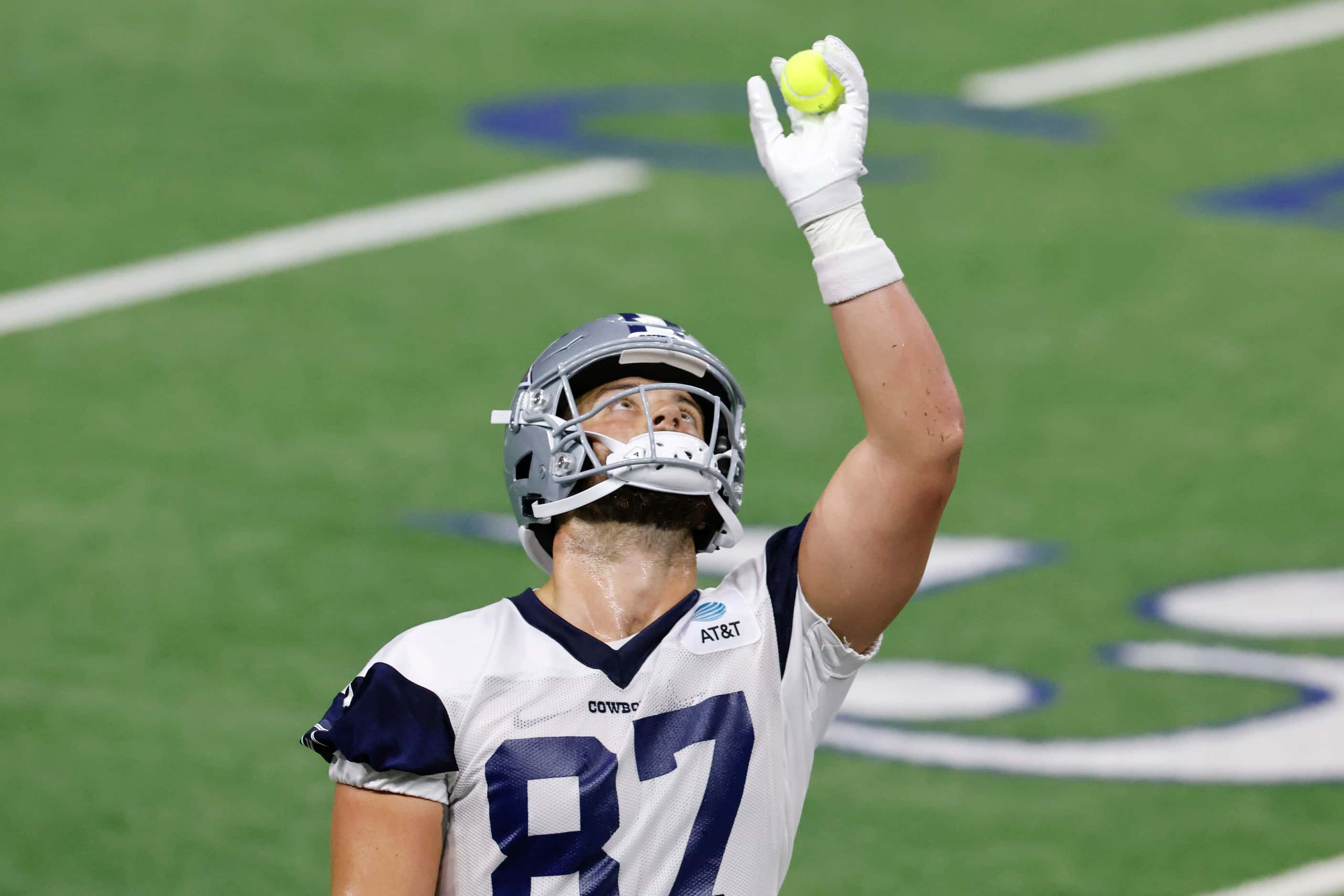 Dallas Cowboys tight end Jake Ferguson (87) catches tennis balls during a drill during the...