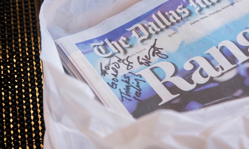 The Dallas Morning News’ Rangers reporter Evan Grant signs a copy of the paper, “Thanks for...