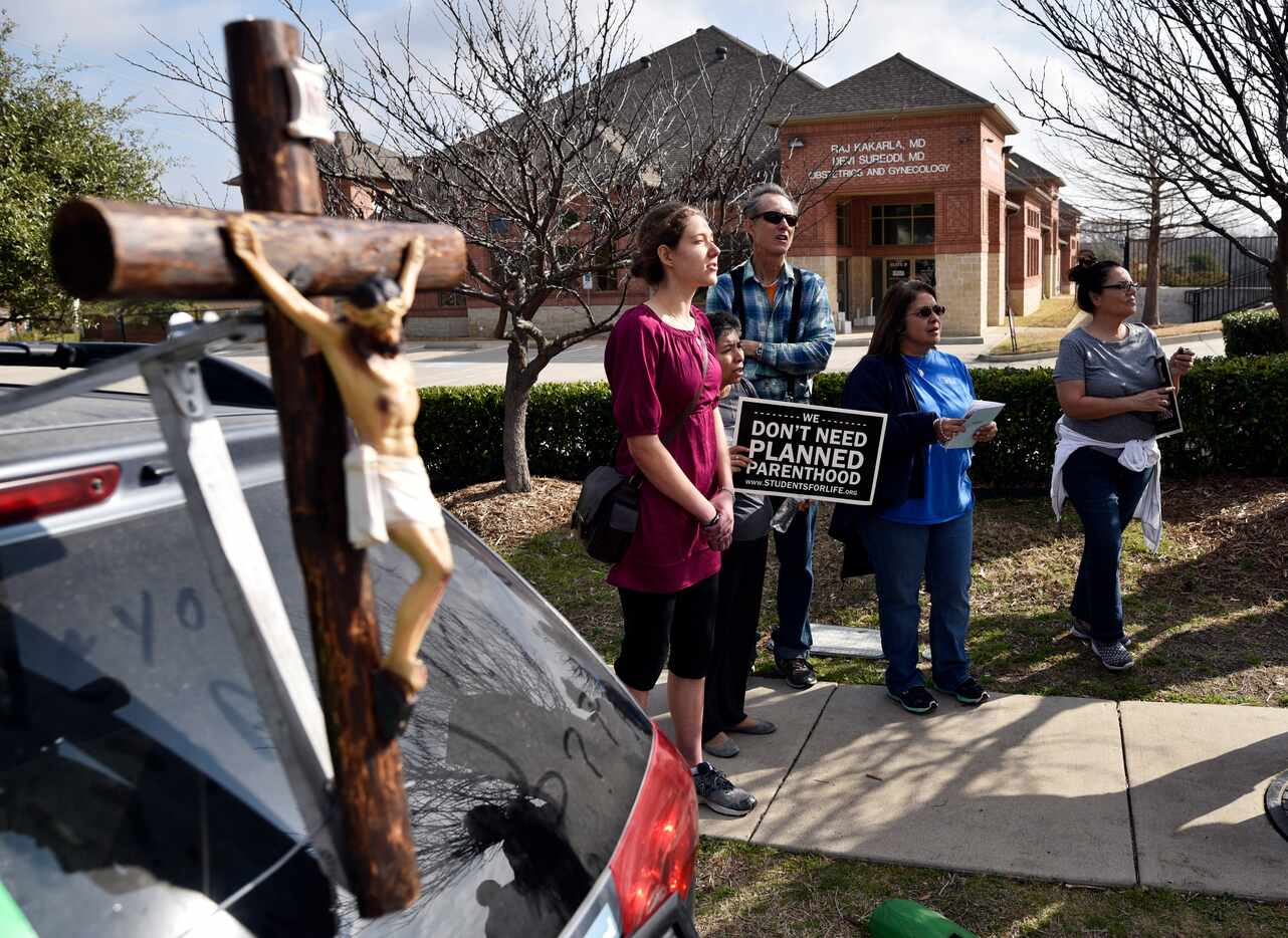 Anna Marinceo, 20, (left) of Flower Mound sang hymns Saturday outside of the Planned...